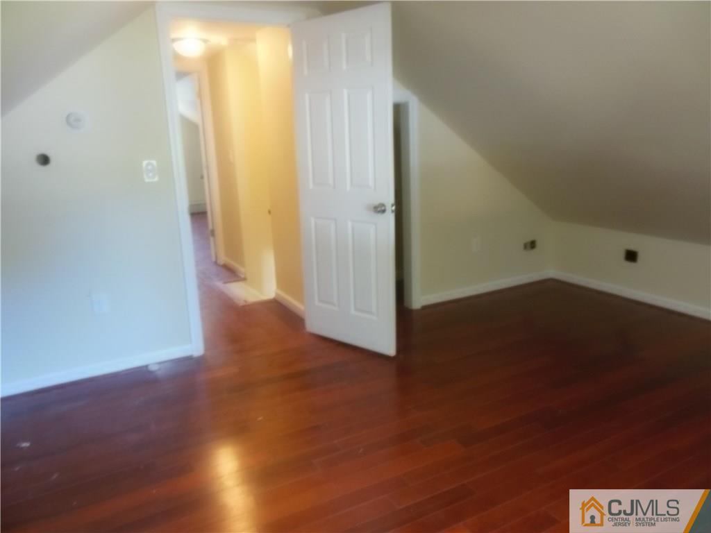 133 Idlewild Road Edison, NJ 08817 - Photo 9 of 11 an empty room with wooden floor