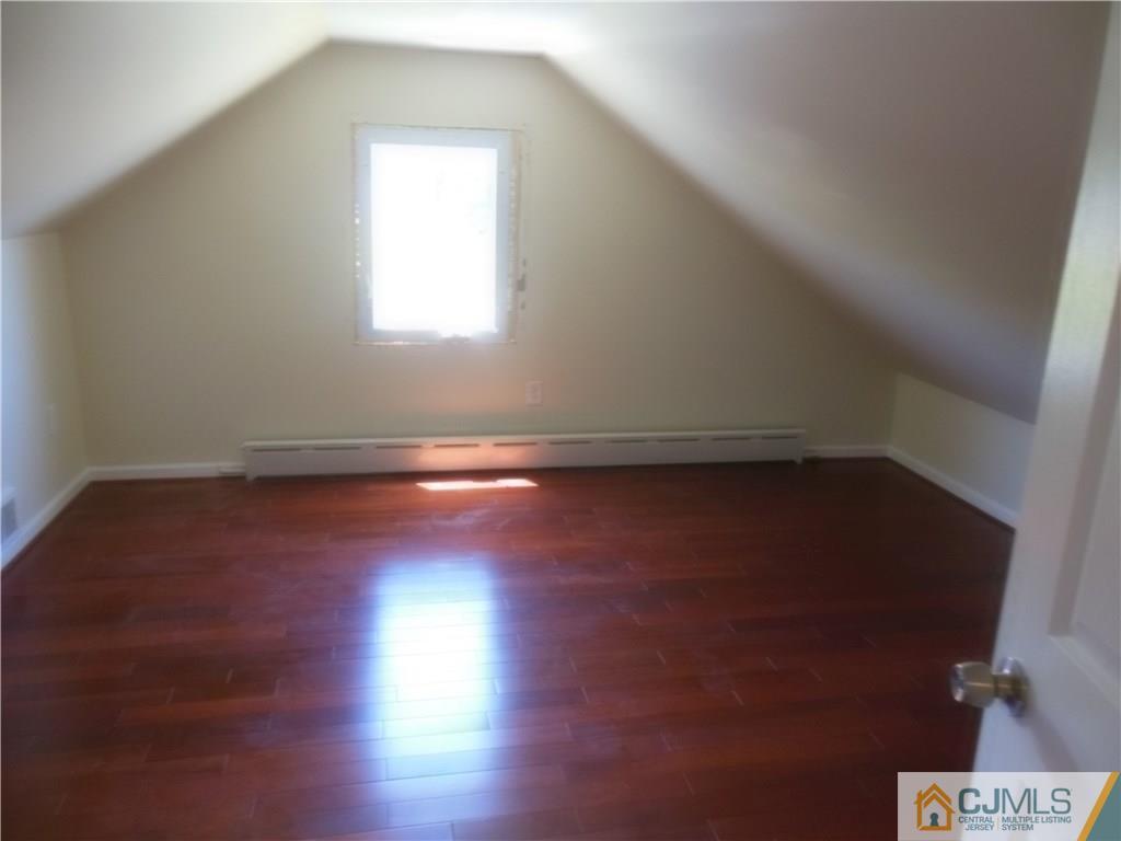 133 Idlewild Road Edison, NJ 08817 - Photo 10 of 11 an empty room with wooden floor and windows