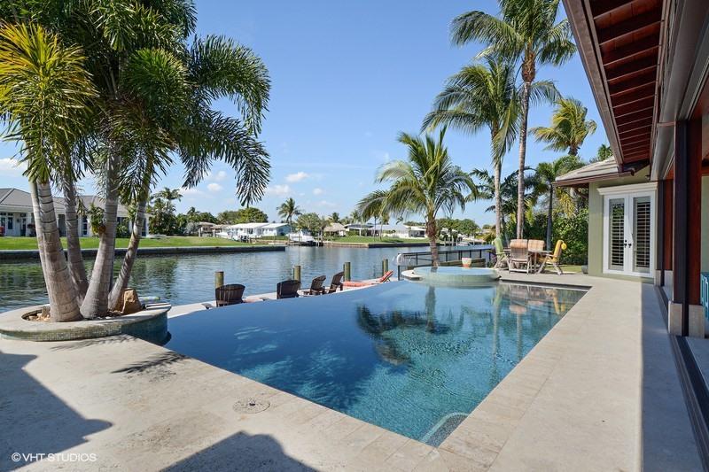 645 Inlet Road North Palm Beach, FL 33408 - Photo 22 of 35 a view of a swimming pool with a table and chairs