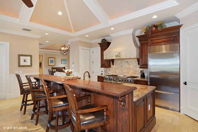 645 Inlet Road North Palm Beach, FL 33408 - Photo 6 of 35 a kitchen with stainless steel appliances granite countertop a stove a refrigerator a dining table and chairs with wooden floor