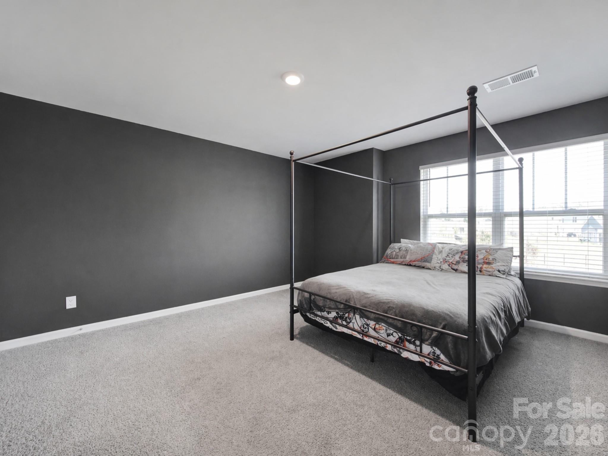 107 Spring Hall Court Troutman, NC 28166 - Photo 19 of 28 a bedroom with a bed and a window