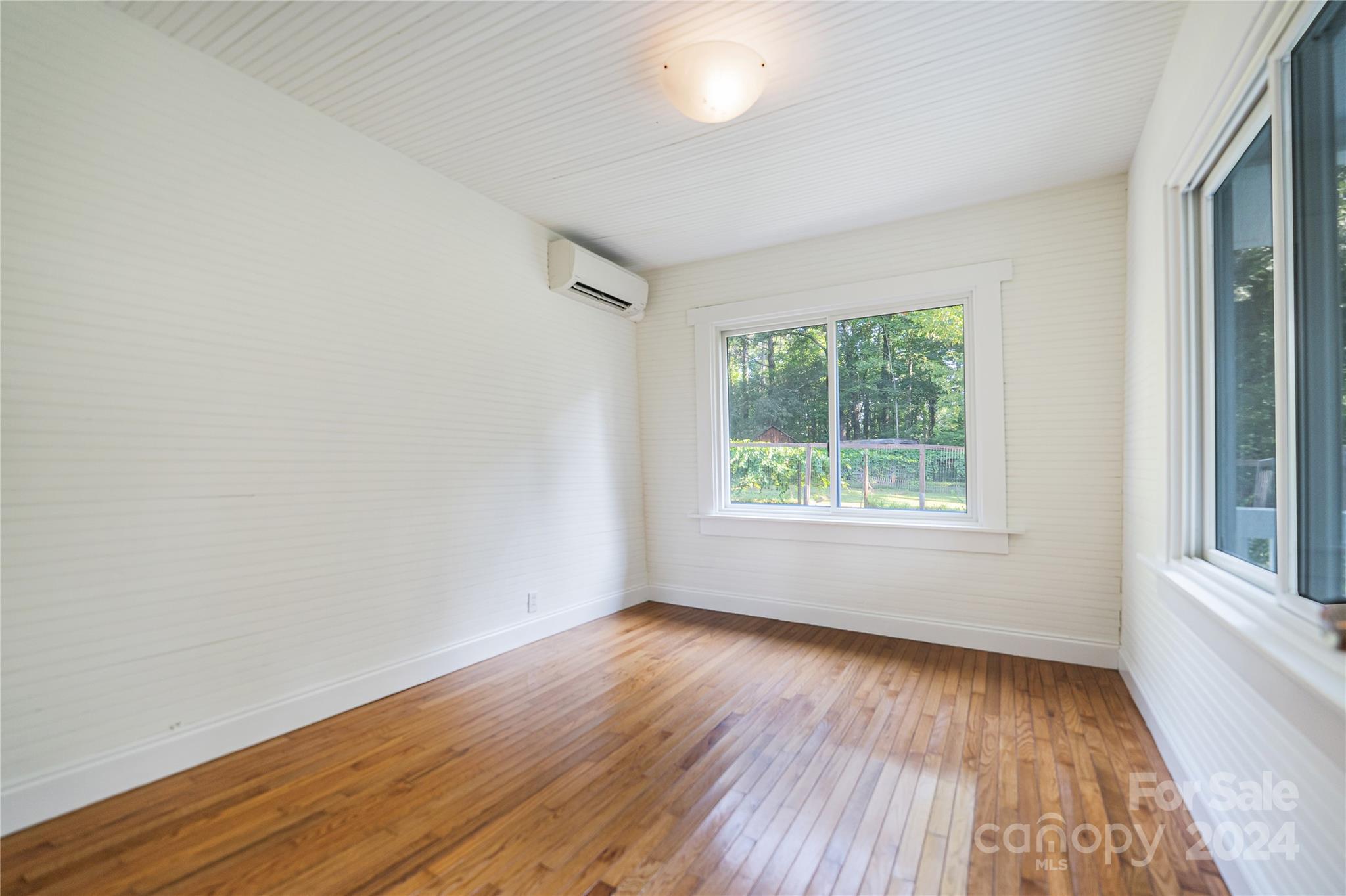 911 Jupiter Road Weaverville, NC 28787 - Photo 15 of 39 a view of an empty room with wooden floor and a window