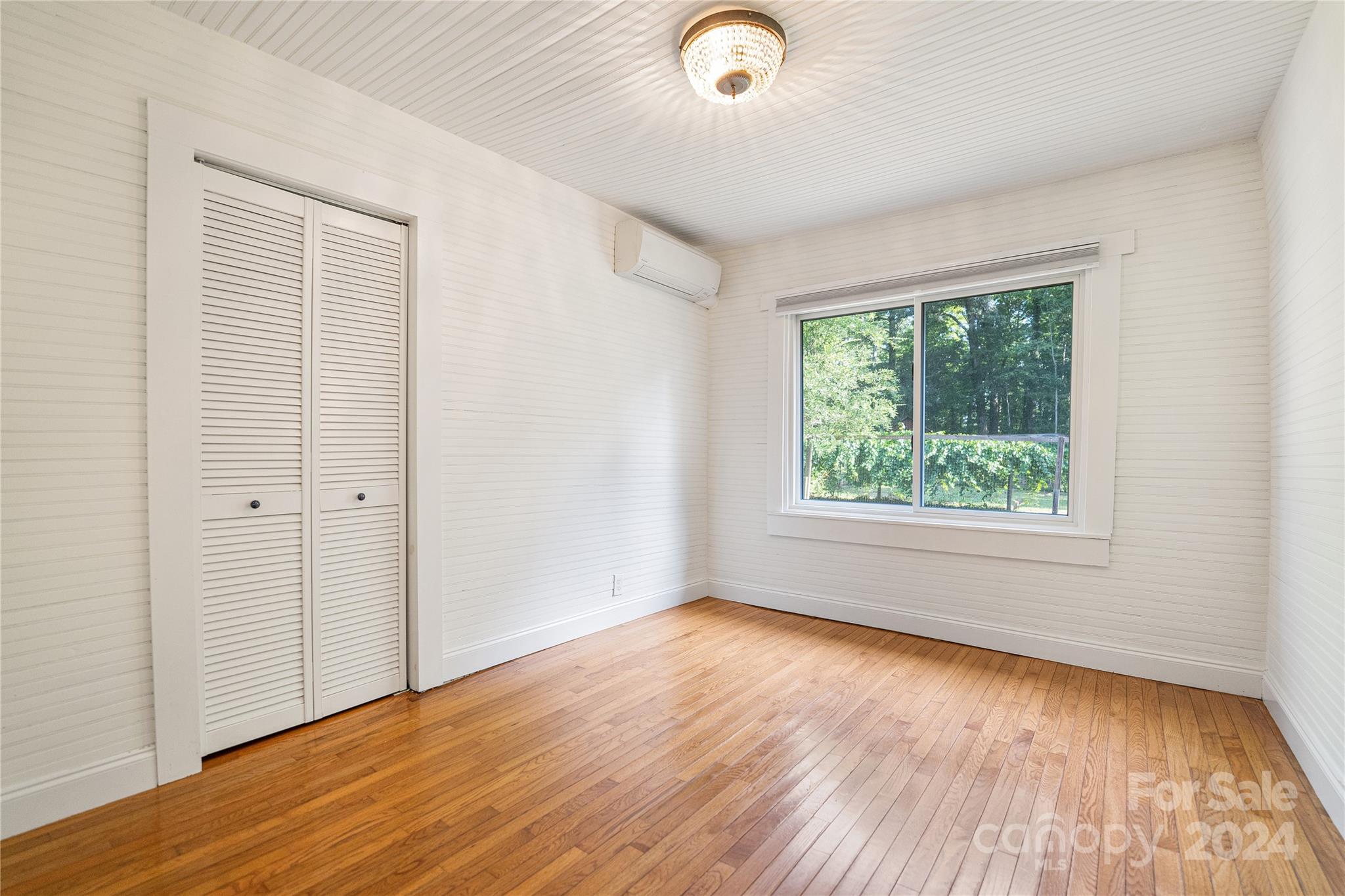 911 Jupiter Road Weaverville, NC 28787 - Photo 17 of 39 an empty room with wooden floor and windows