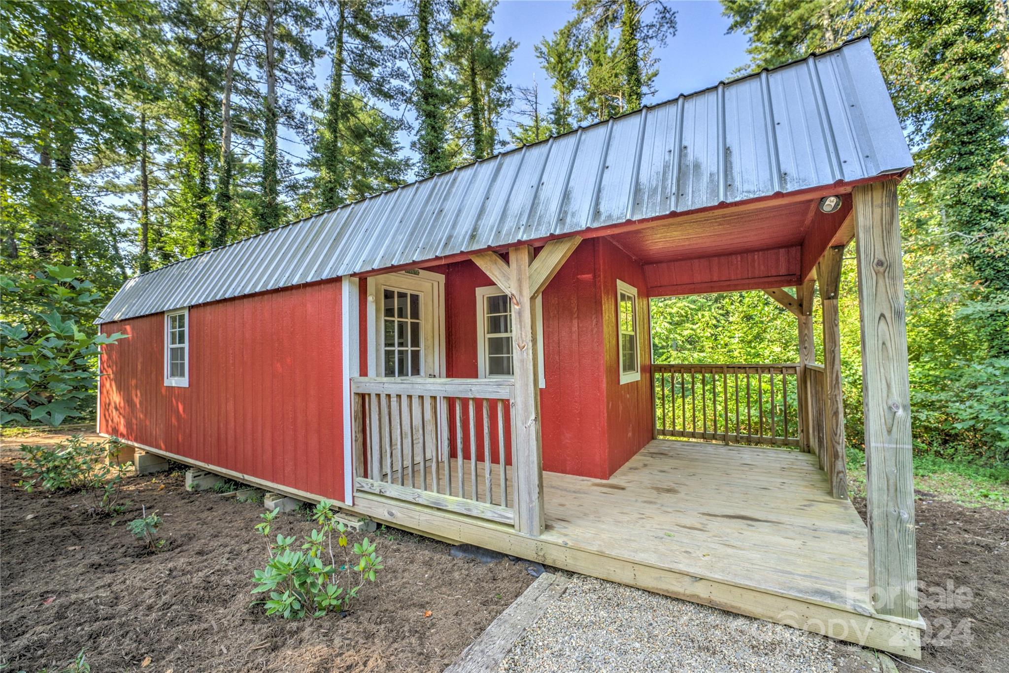 911 Jupiter Road Weaverville, NC 28787 - Photo 28 of 39 a backyard of a house with a small barn plants and wooden fence