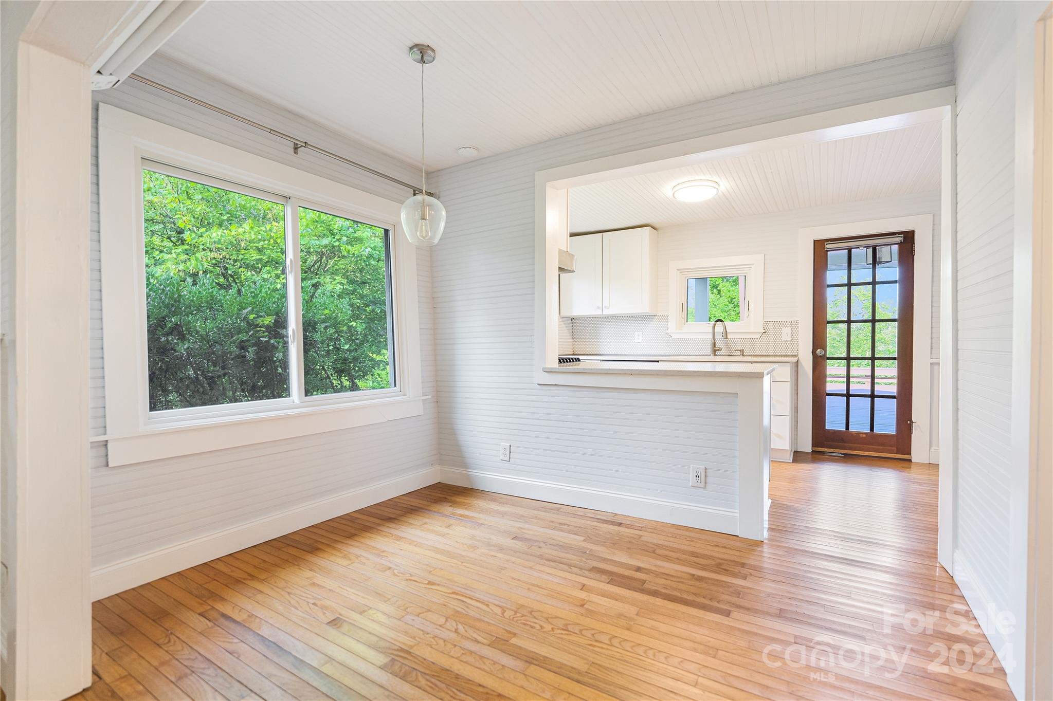 911 Jupiter Road Weaverville, NC 28787 - Photo 10 of 39 a view of a kitchen and an empty room with wooden floor and a window