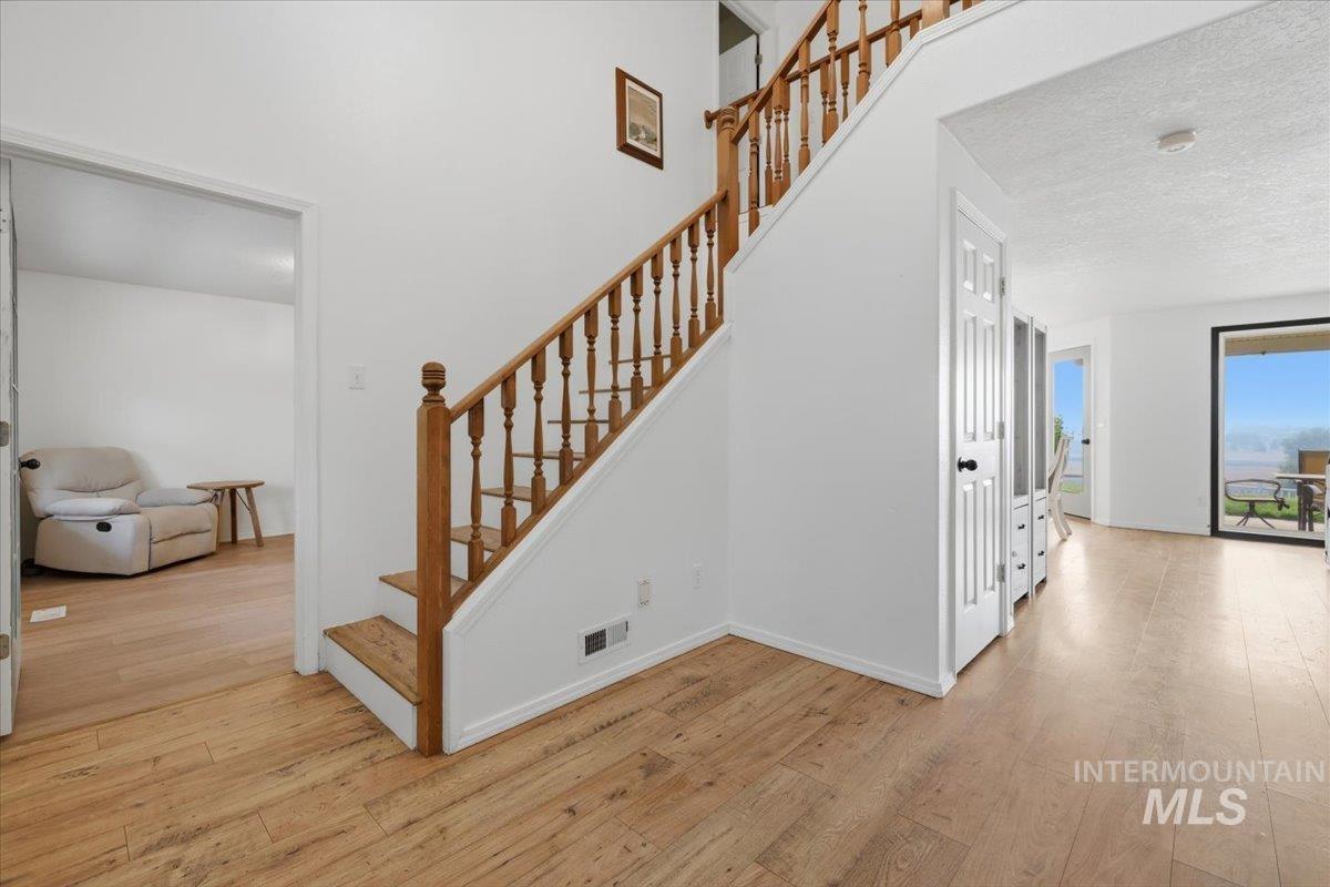 24440 Kenridge Road Caldwell, ID 83607 - Photo 8 of 48 Hardwood-finish flooring extending throughout the space, featuring a staircase with wood balusters and handrail