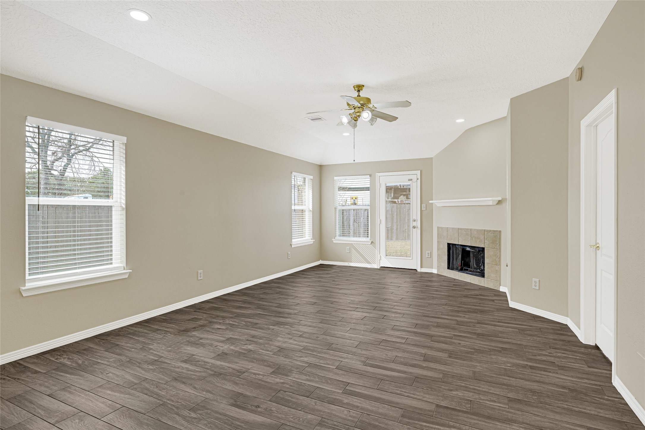 2518 Forge Creek Road Houston, TX 77067 - Photo 12 of 25 a view of empty room with wooden floor and fireplace
