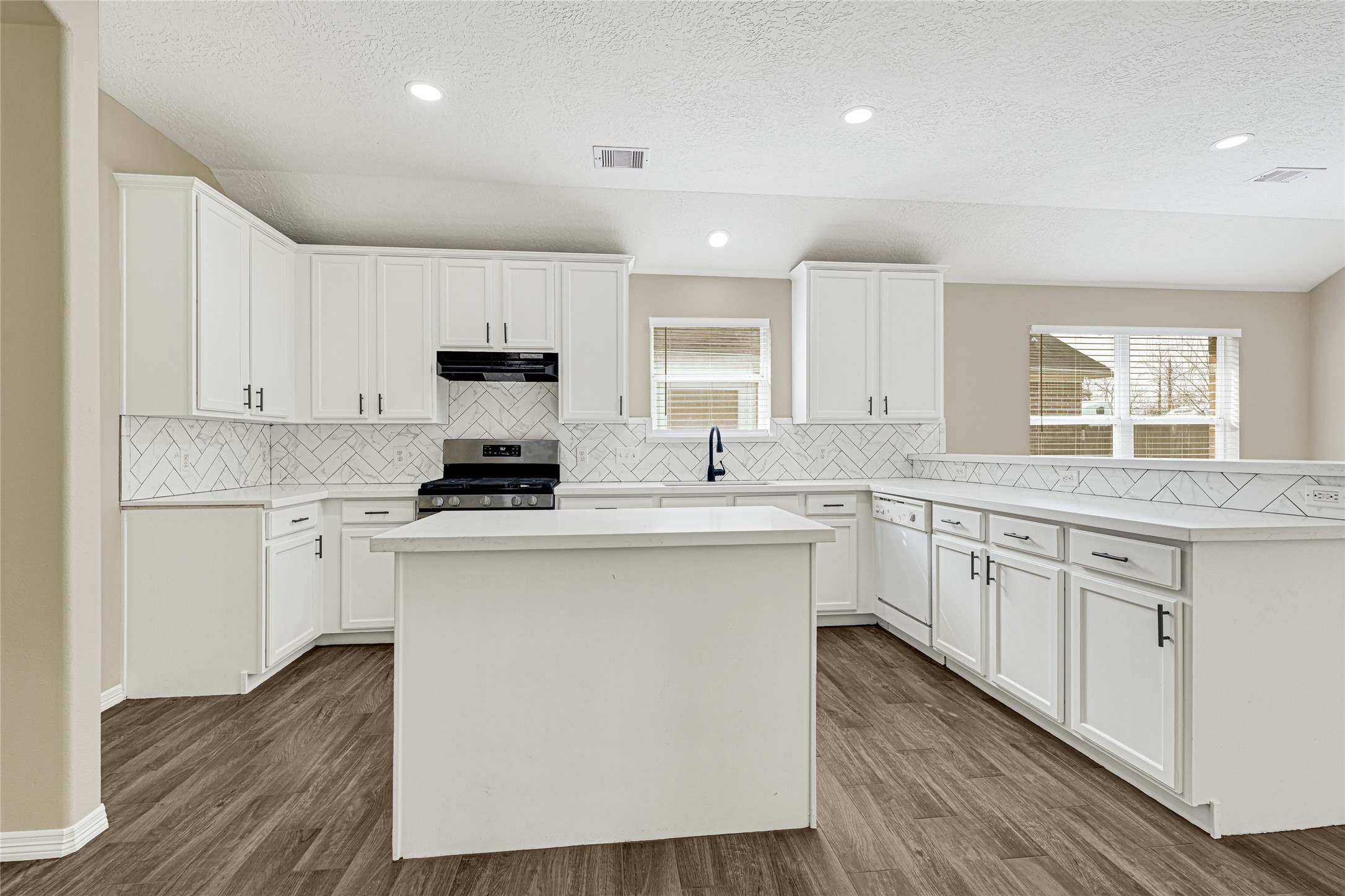 2518 Forge Creek Road Houston, TX 77067 - Photo 7 of 25 a kitchen with stainless steel appliances granite countertop white cabinets a sink a stove a microwave and wooden floors