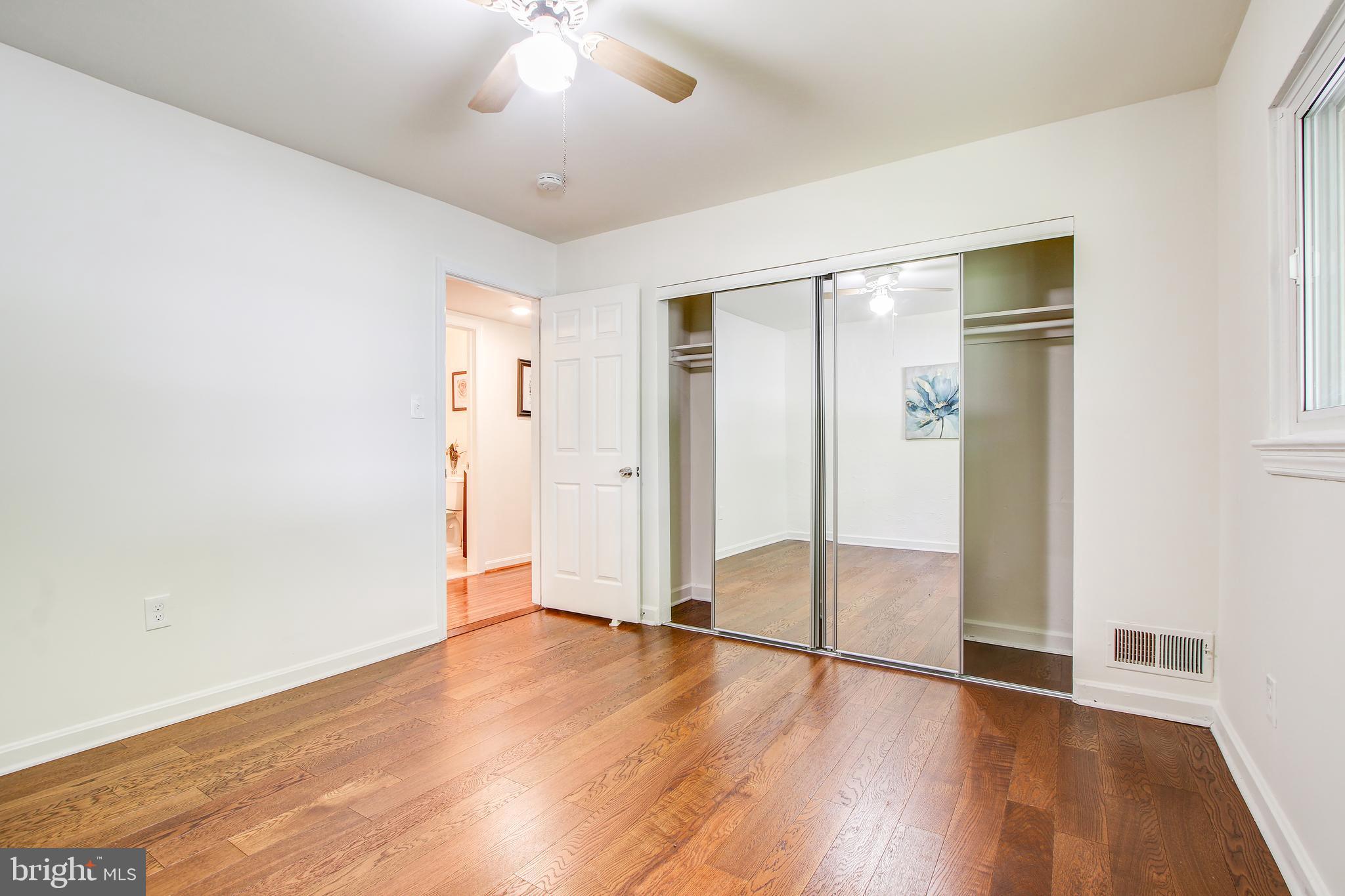 702 Dryden Street Silver Spring, MD 20901 - Photo 16 of 31 an empty room with wooden floor and a ceiling fan