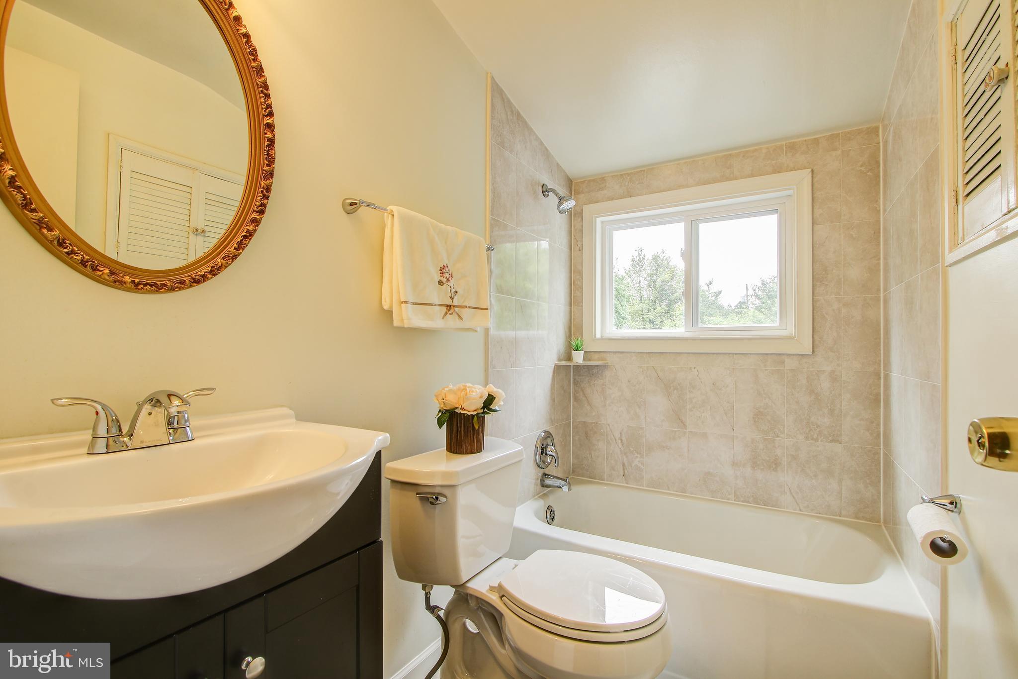 702 Dryden Street Silver Spring, MD 20901 - Photo 20 of 31 a bathroom with a sink a toilet and a mirror