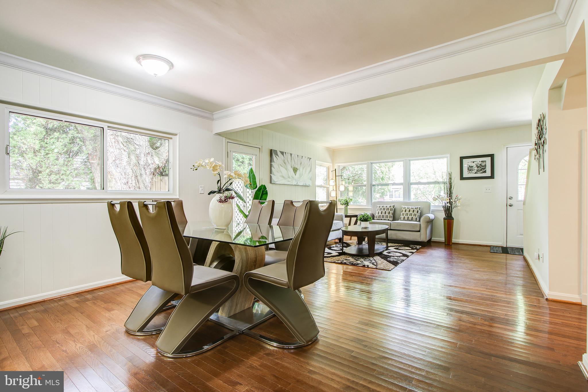 702 Dryden Street Silver Spring, MD 20901 - Photo 5 of 31 a dining room with wooden floor a glass table and chairs