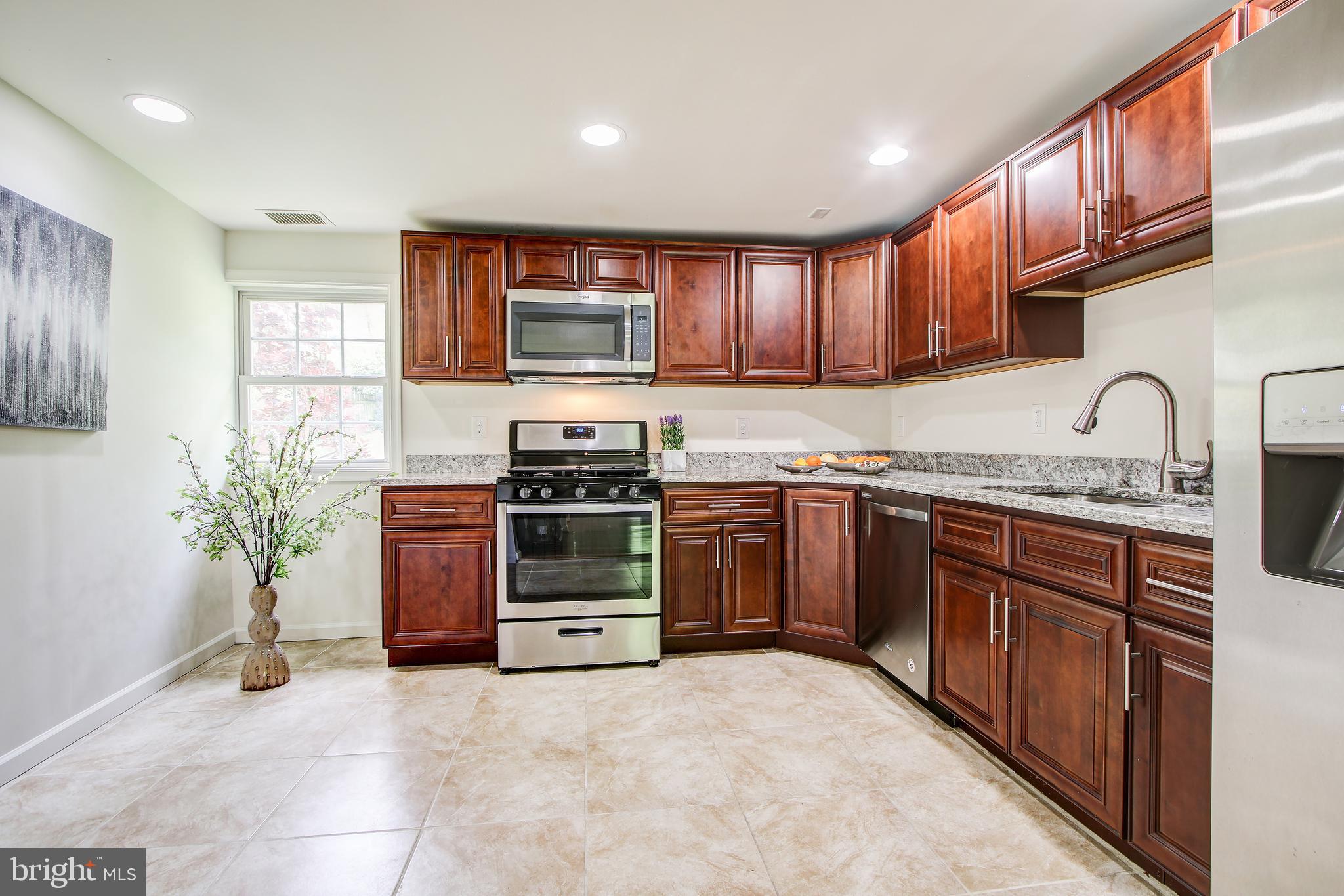 702 Dryden Street Silver Spring, MD 20901 - Photo 6 of 31 a kitchen with stainless steel appliances granite countertop a stove a sink and a microwave