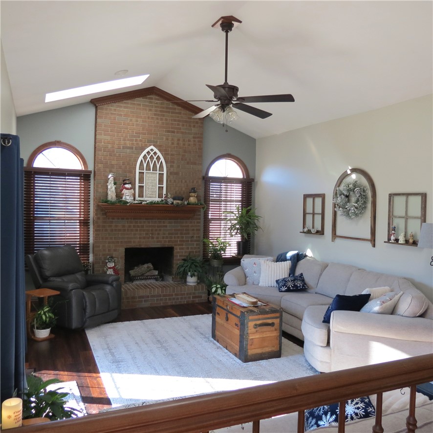 10160 Lochard Road Sidney, OH 45365 - Photo 9 of 41 This inviting living space features soaring ceilings and a cozy brick fireplace, perfect for gatherings.