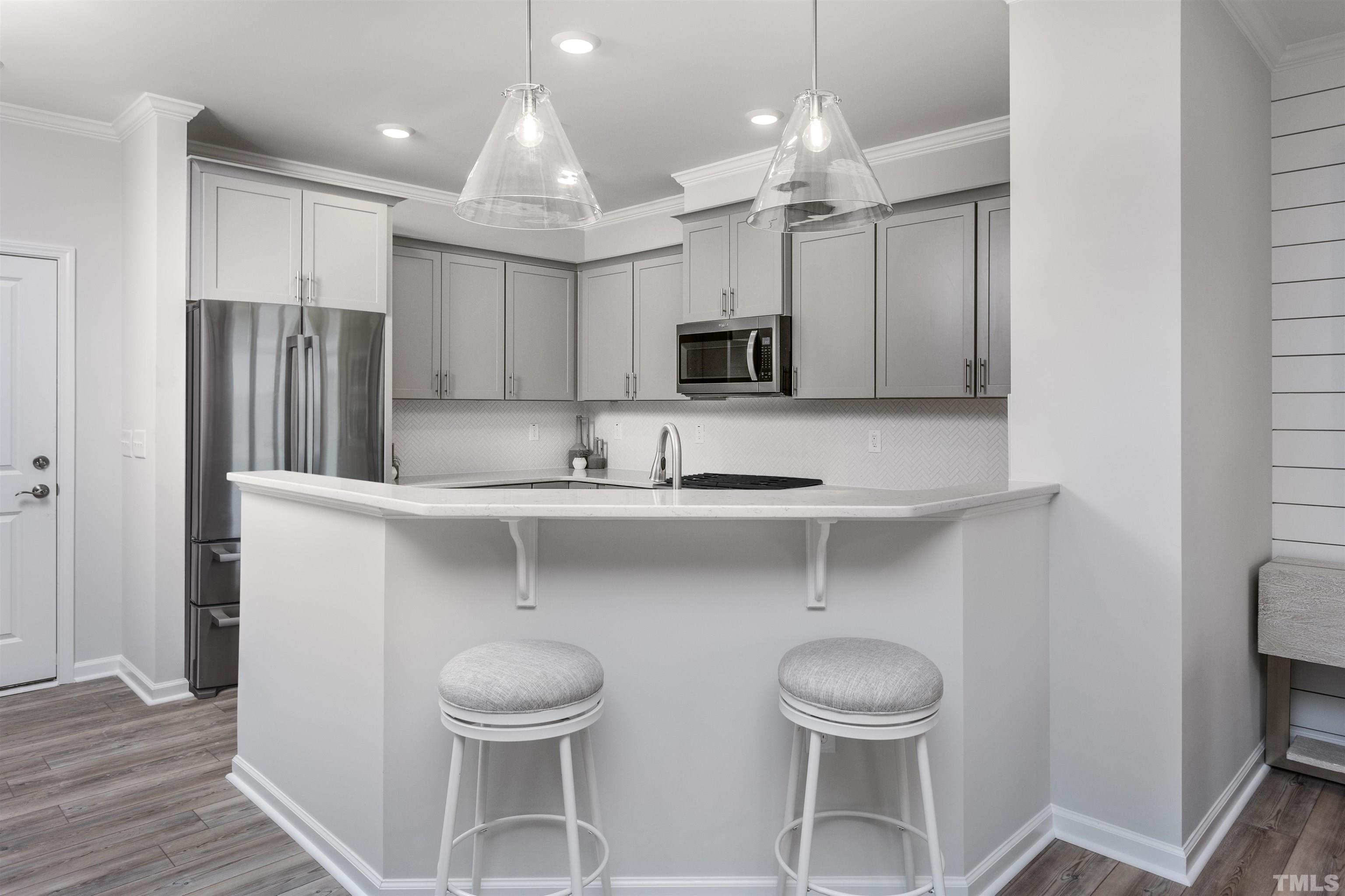 4808 Megara Run Raleigh, NC 27603 - Photo 8 of 23 a kitchen with stainless steel appliances a table and chairs in it