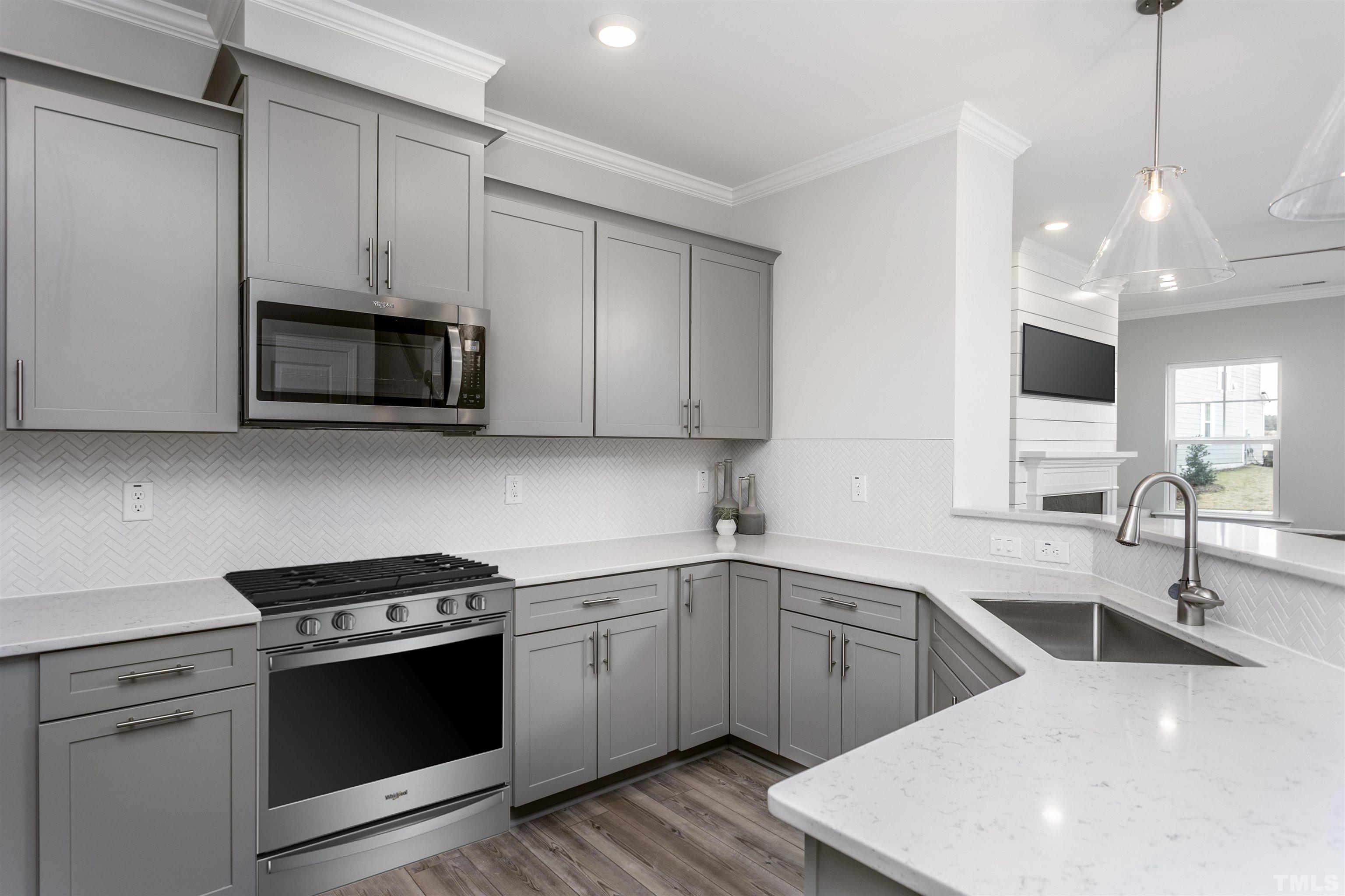4808 Megara Run Raleigh, NC 27603 - Photo 9 of 23 a kitchen with stainless steel appliances a sink a stove a microwave and wooden cabinets