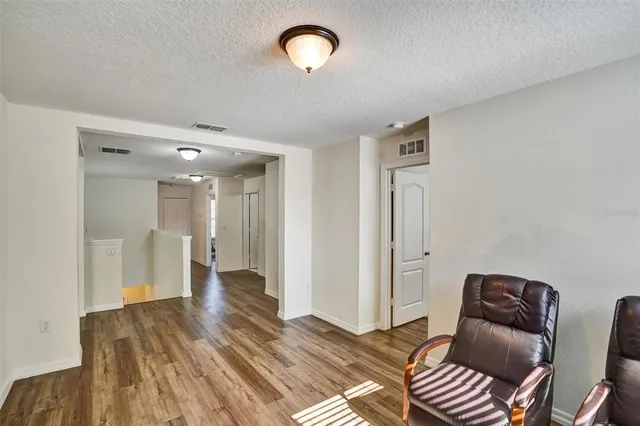 a view of a livingroom with furniture hardwood floor and hallway