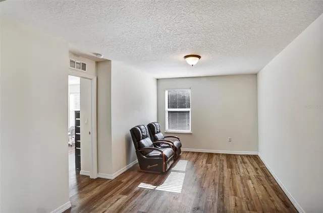 a view of a room with wooden floor lounge chair and windows
