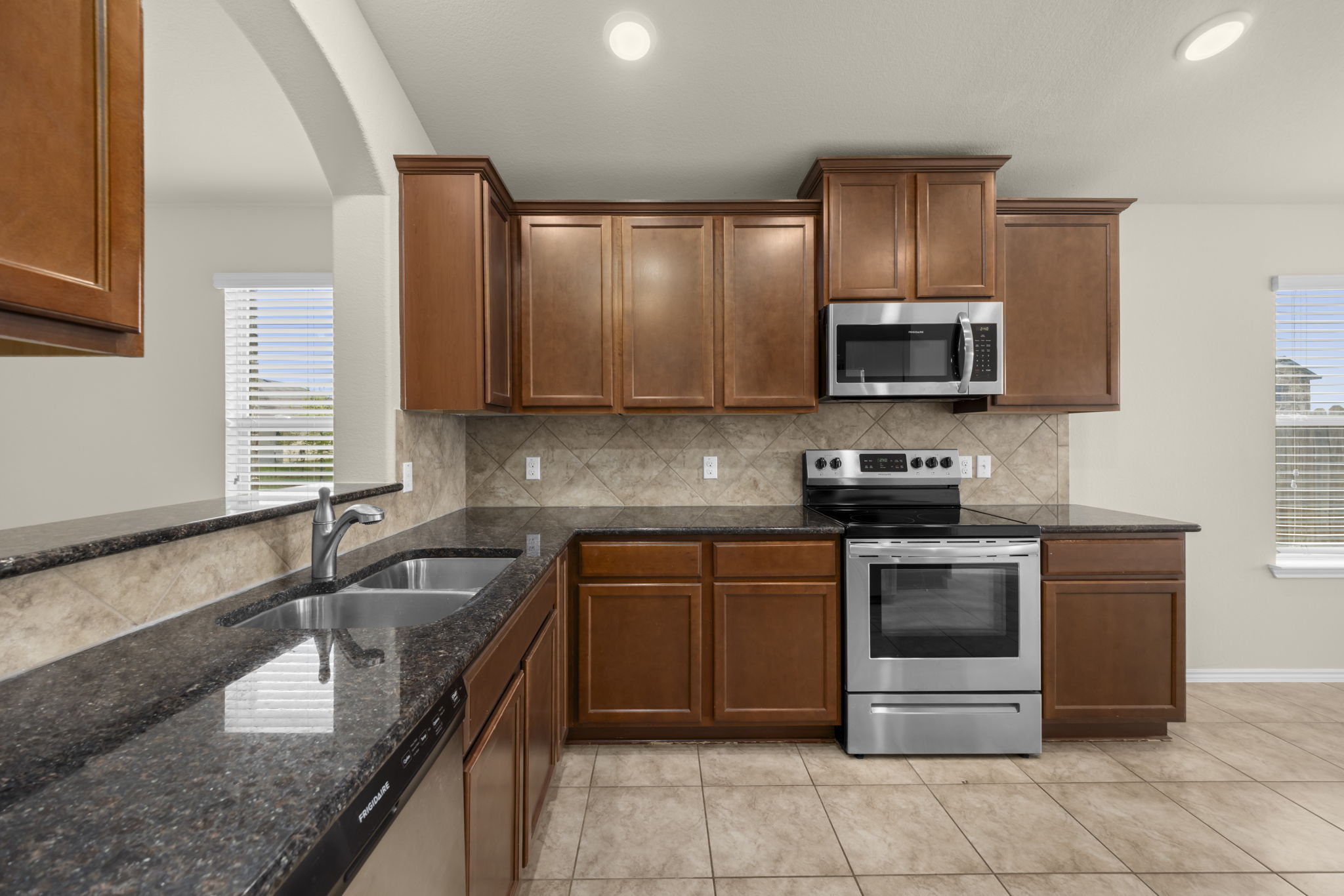 101 Plata Lane Jarrell, TX 76537 - Photo 16 of 27 a kitchen with stainless steel appliances granite countertop a sink stove and microwave