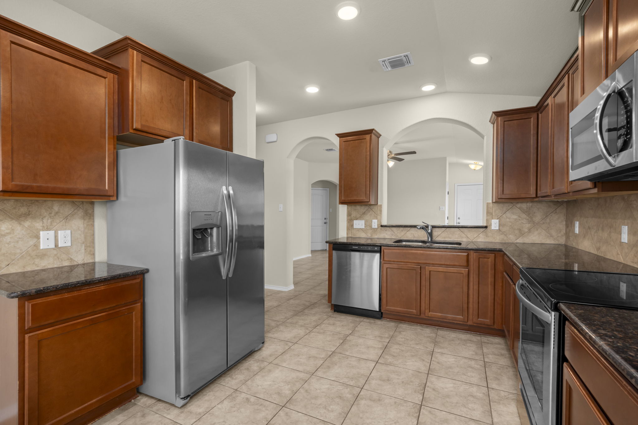 101 Plata Lane Jarrell, TX 76537 - Photo 18 of 27 a kitchen with stainless steel appliances granite countertop a refrigerator sink and stove