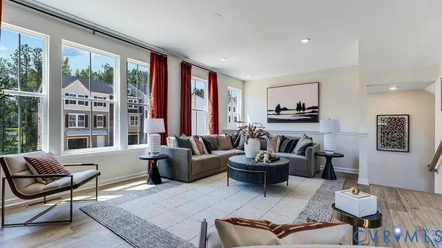 a view of kitchen and empty room with wooden floor