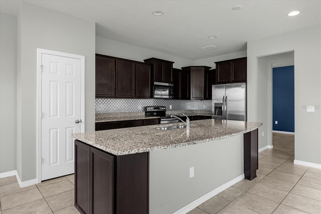 3504 Southern Cross Loop Kissimmee, FL 34744 - Photo 11 of 27 a kitchen with stainless steel appliances granite countertop a sink stove and refrigerator