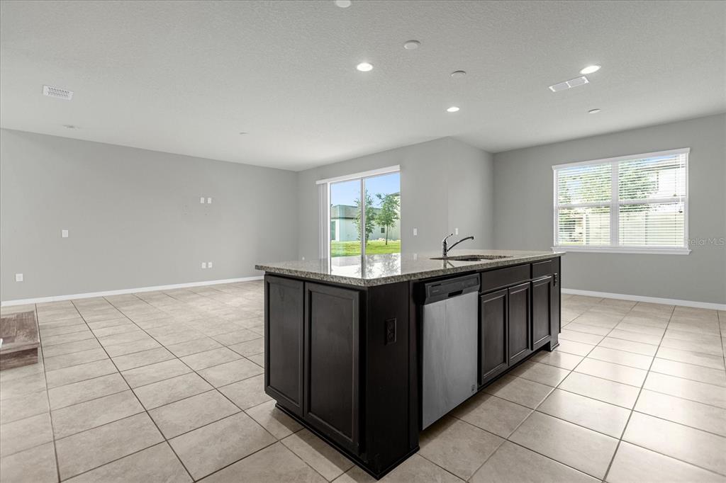 3504 Southern Cross Loop Kissimmee, FL 34744 - Photo 13 of 27 a kitchen with stainless steel appliances granite countertop a sink and a white cabinets