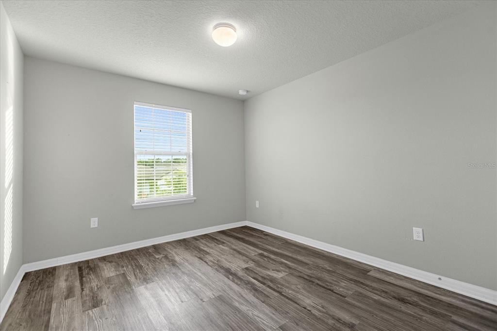 3504 Southern Cross Loop Kissimmee, FL 34744 - Photo 16 of 27 an empty room with wooden floor and windows