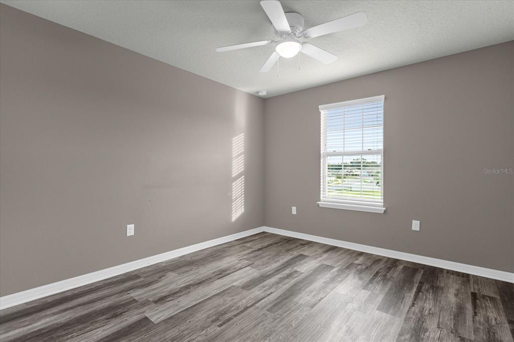 3504 Southern Cross Loop Kissimmee, FL 34744 - Photo 18 of 27 wooden floor in an empty room with a window