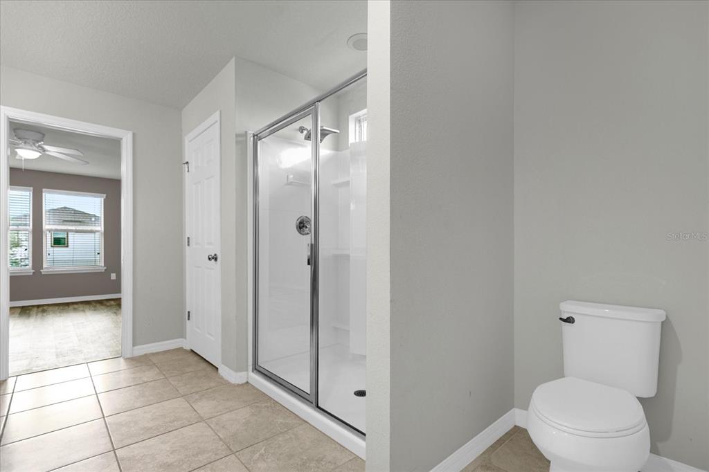 3504 Southern Cross Loop Kissimmee, FL 34744 - Photo 25 of 27 a bathroom with a toilet a sink and glass door