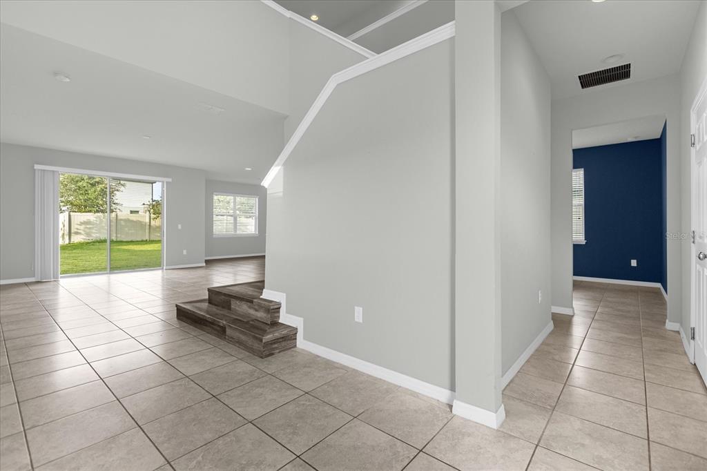 3504 Southern Cross Loop Kissimmee, FL 34744 - Photo 5 of 27 a living room with a black white checkered floor with a gaming machine and a next to a window