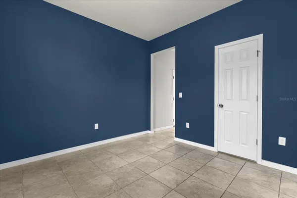 a view of an empty room with closet and bathroom