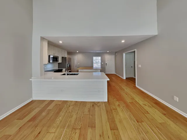 a view of kitchen with wooden floor and electronic appliances