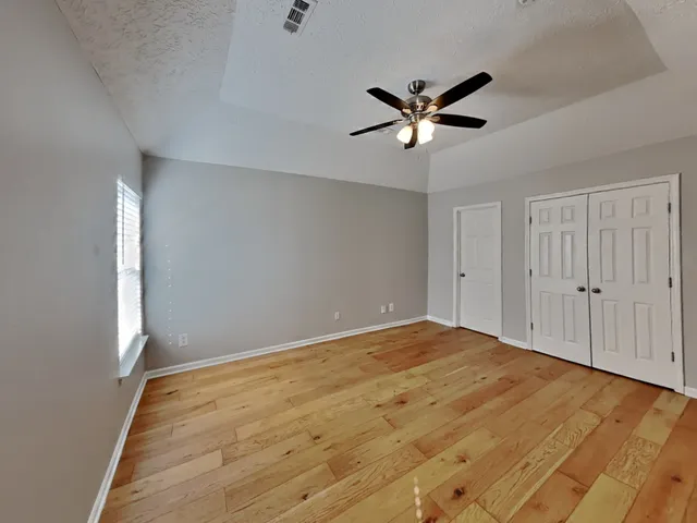 a view of empty room with wooden floor