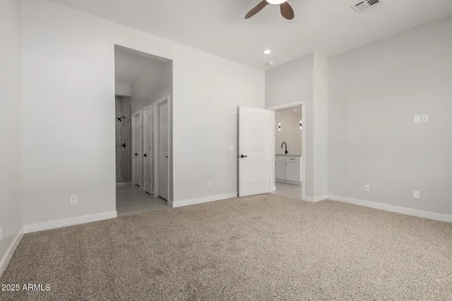 an empty room with fan and entrance