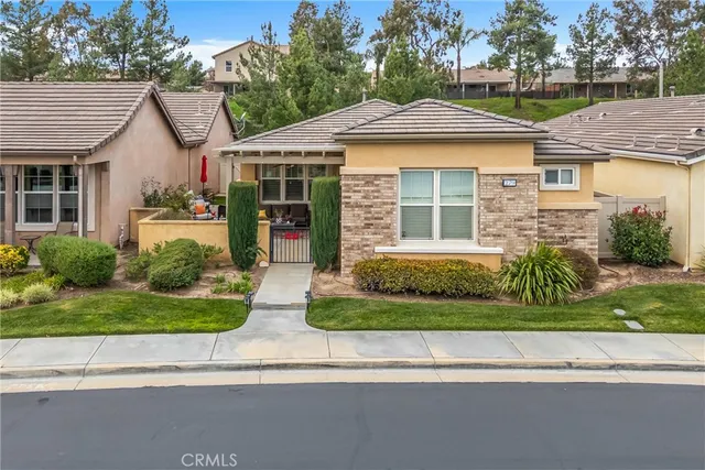 a front view of a house with a yard and potted plants