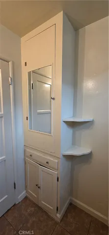 an empty room with wooden floor and cabinet