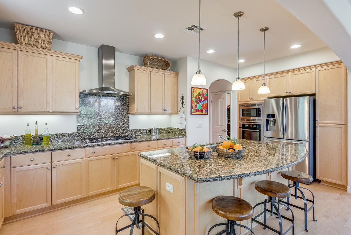 7680 MacKenzie Way Gilroy, CA 95020 - Photo 19 of 61 a kitchen with granite countertop a table chairs stove refrigerator and microwave