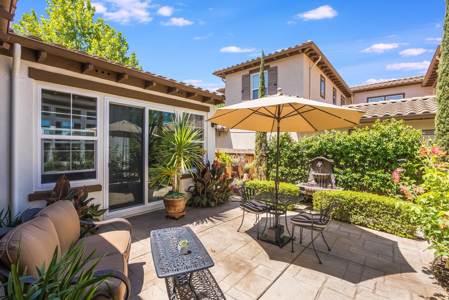 7680 MacKenzie Way Gilroy, CA 95020 - Photo 45 of 61 a view of a patio with couches table and chairs under an umbrella with a fire pit