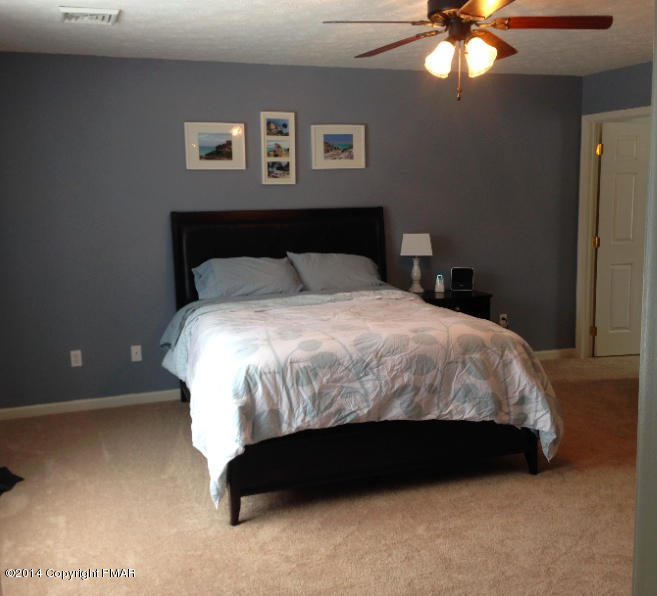 1148 Sunside Road Long Pond, PA 18334 - Photo 7 of 20 a bedroom with a bed and a chandelier