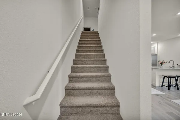 a view of a bedroom with a bed and wooden floor