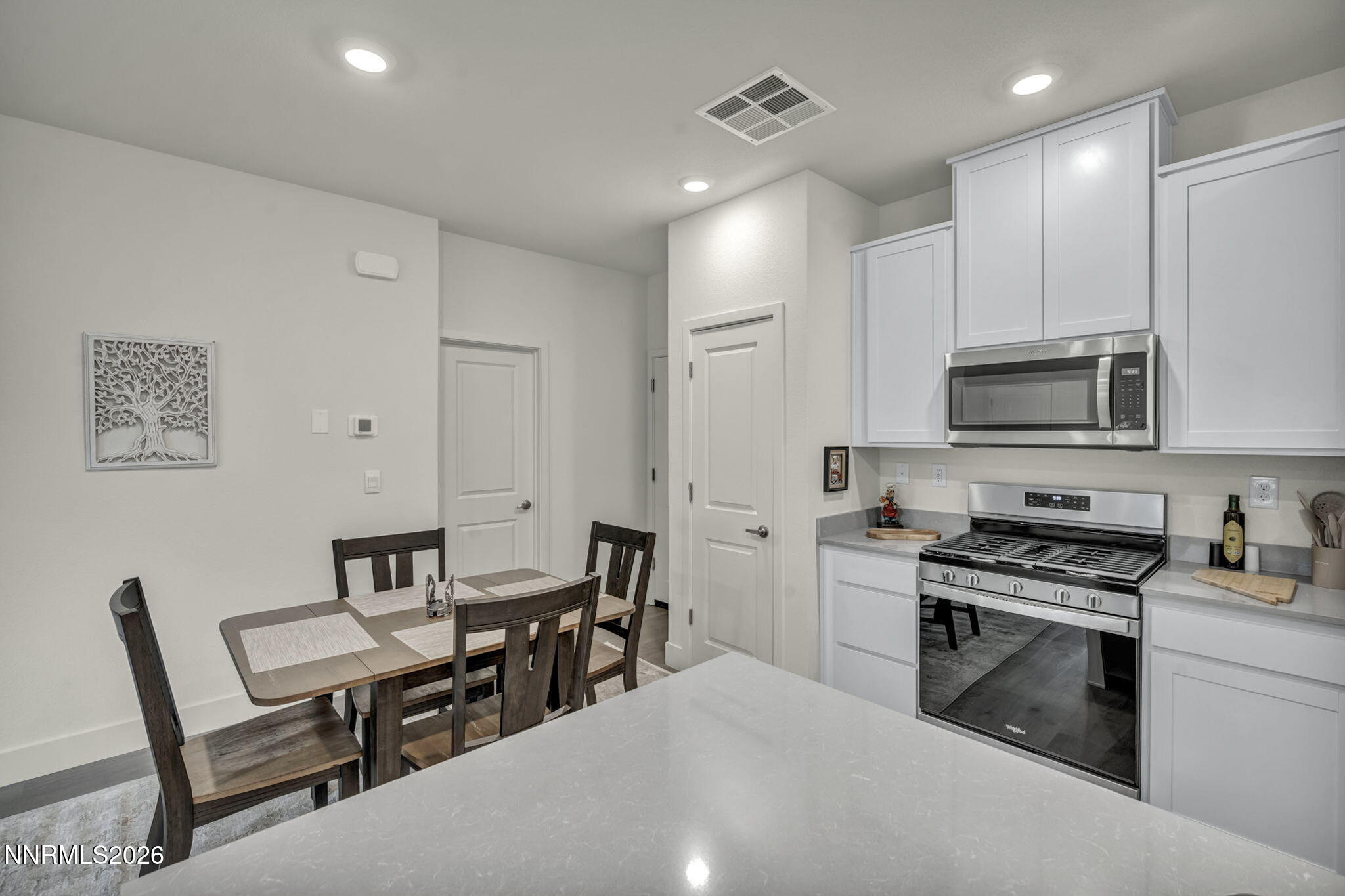1634 Icelandic Way Reno, NV 89523 - Photo 6 of 49 a kitchen with stainless steel appliances a stove a sink a microwave a dining table and chairs