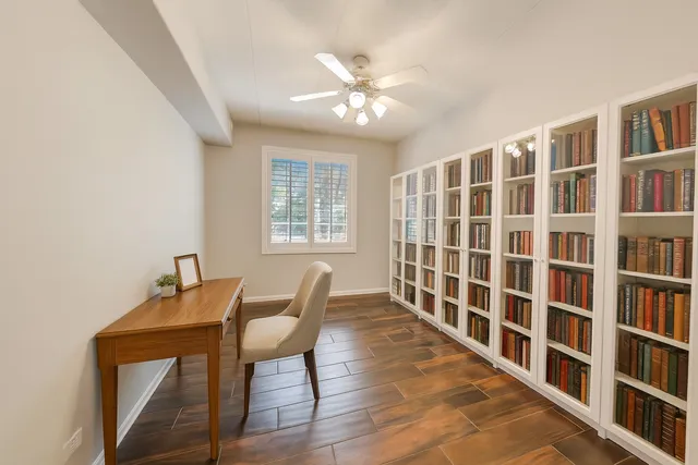 a view of a room with wooden floor a chandelier fan and a window
