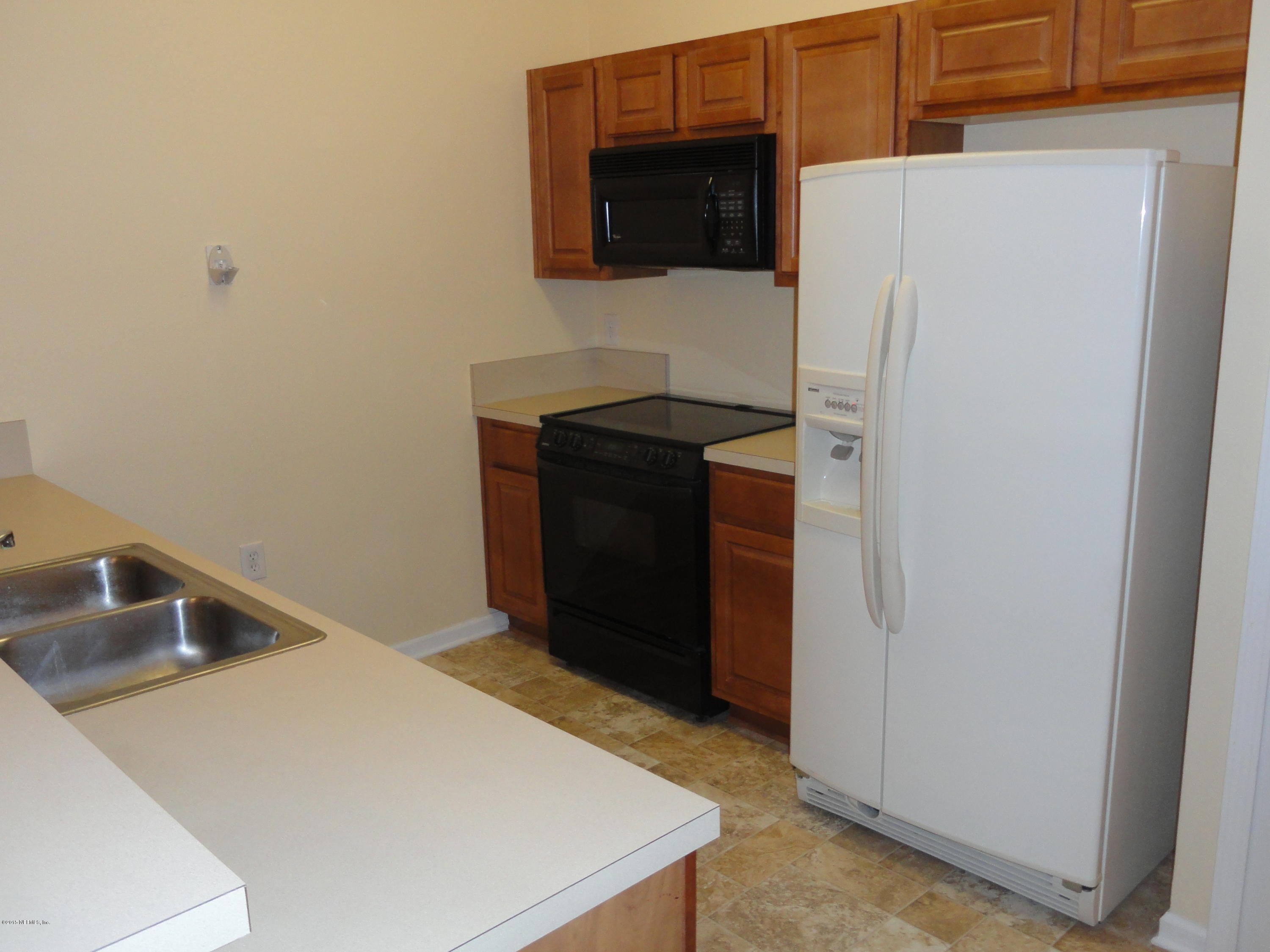 7920 Merrill Road, Unit 1505 Jacksonville, FL 32277 - Photo 7 of 19 a kitchen with a refrigerator and a sink