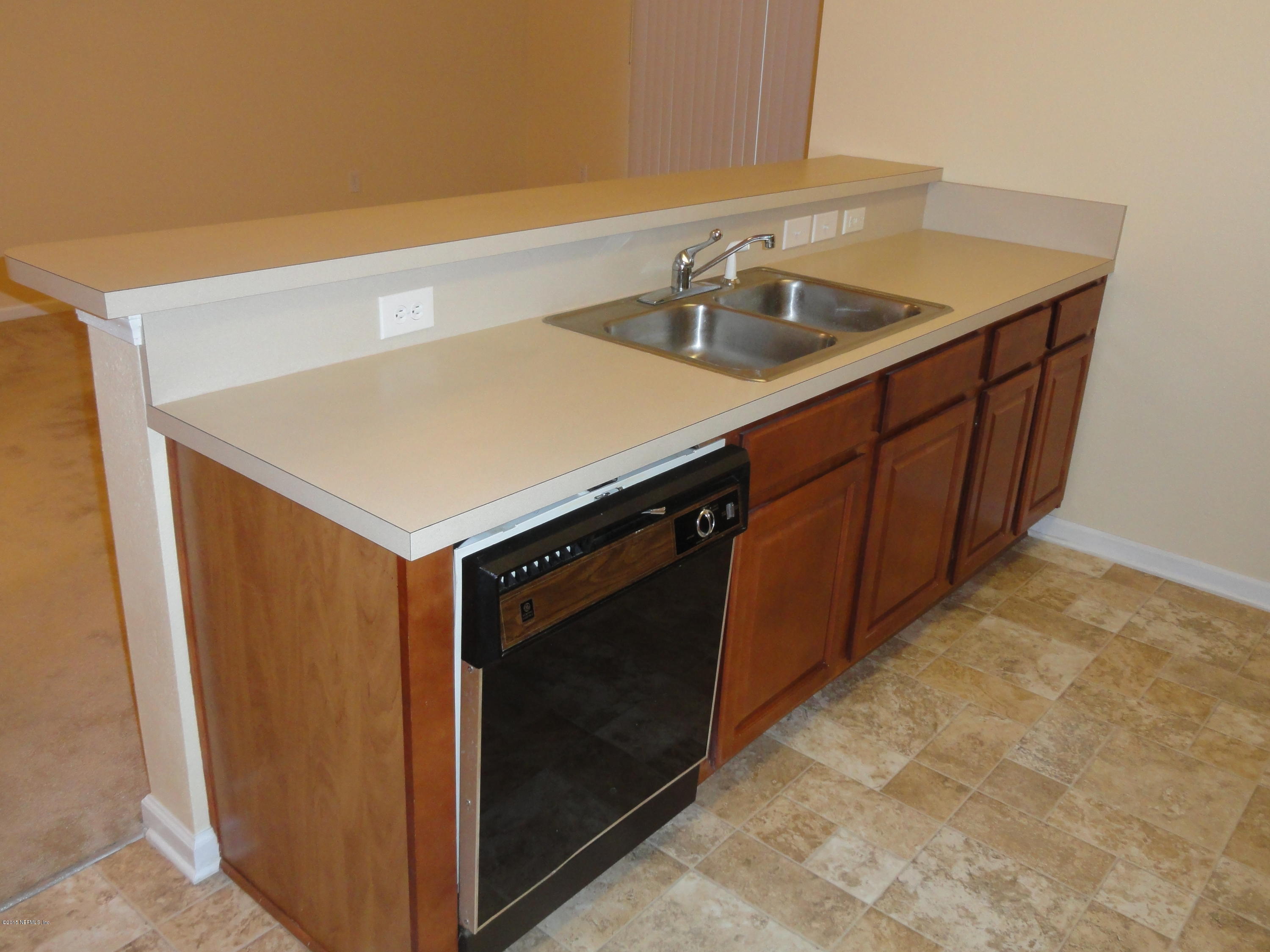 7920 Merrill Road, Unit 1505 Jacksonville, FL 32277 - Photo 8 of 19 a kitchen with a sink cabinets and a stove