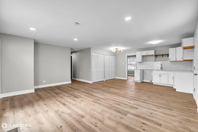 a view of large kitchen with a sink and cabinets