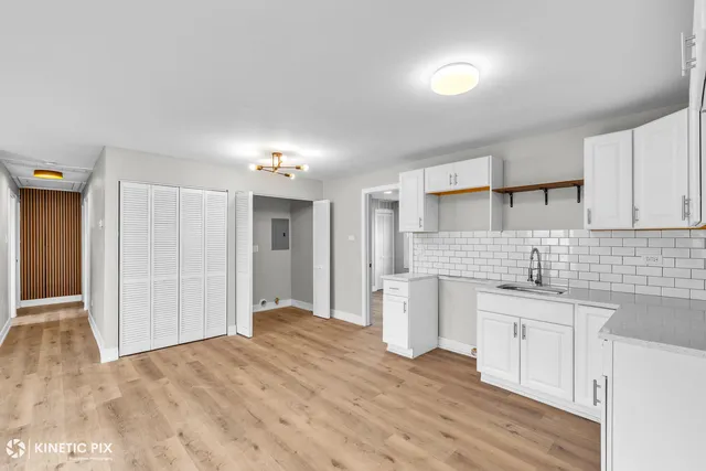 a kitchen with a sink cabinets and wooden floor