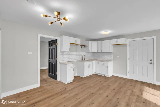 a kitchen with a refrigerator and white cabinets