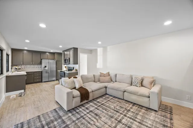 a living room with furniture and view of kitchen
