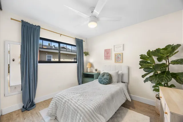 a bedroom with a bed and a potted plant