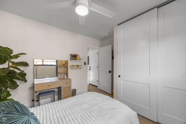 a bedroom with a bed and a computer on the dresser